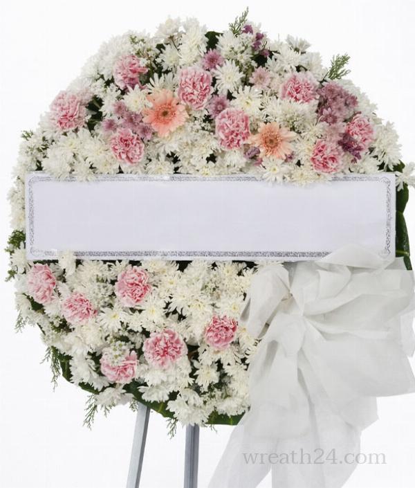 พวงหรีดโทนชมพูอ่อนผสมขาวรูปทรงกลมให้ความรู้สึกอ่อนโยนและอบอุ่น