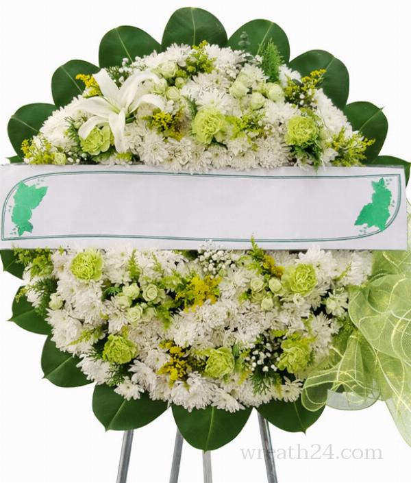 พวงหรีดสีขาวเขียวแซมใบไม้สดจัดแน่นให้ความรู้สึกธรรมชาติและสงบเรียบร้อย